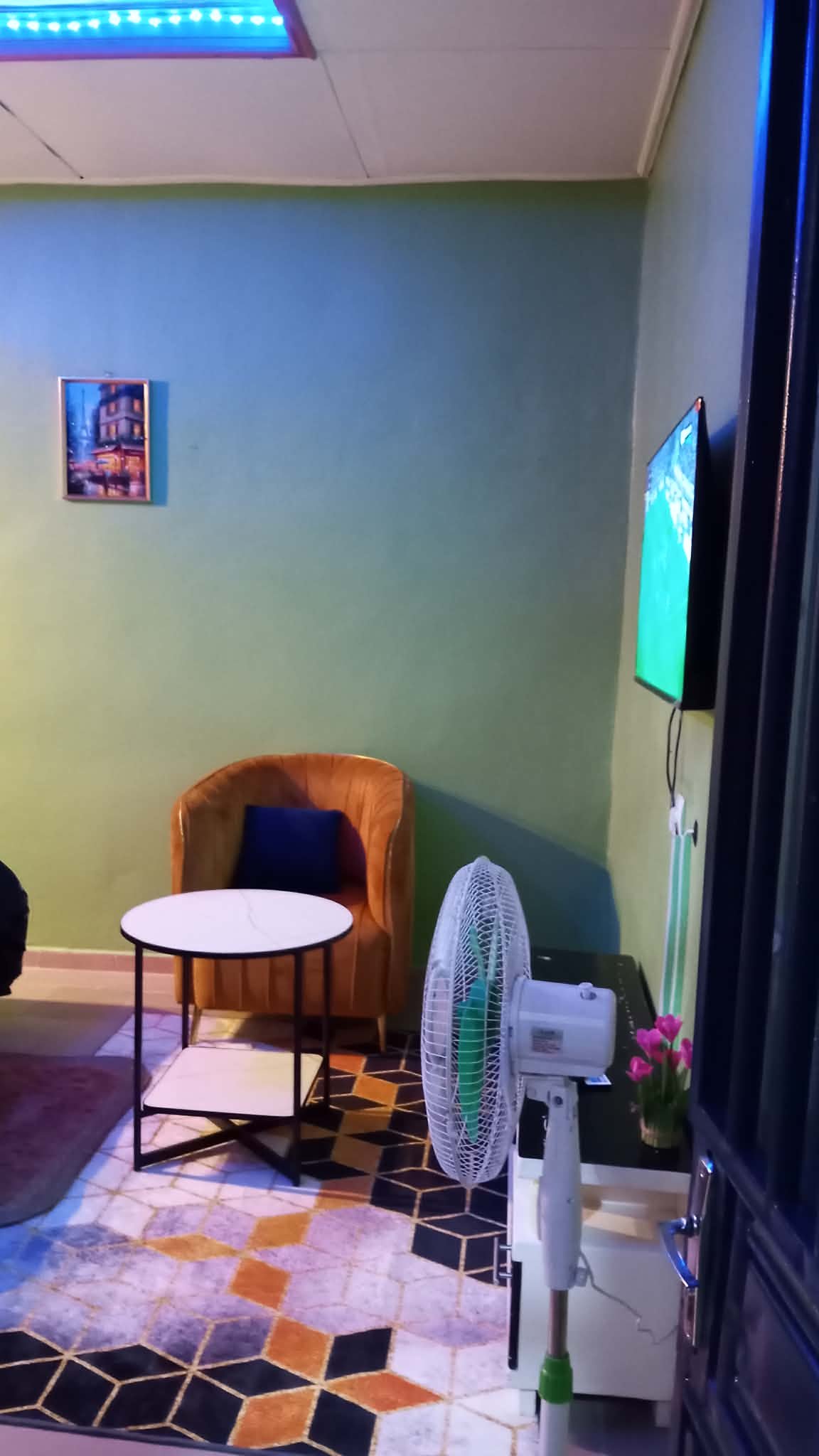 Espace détente du studio avec fauteuil, table basse et téléviseur