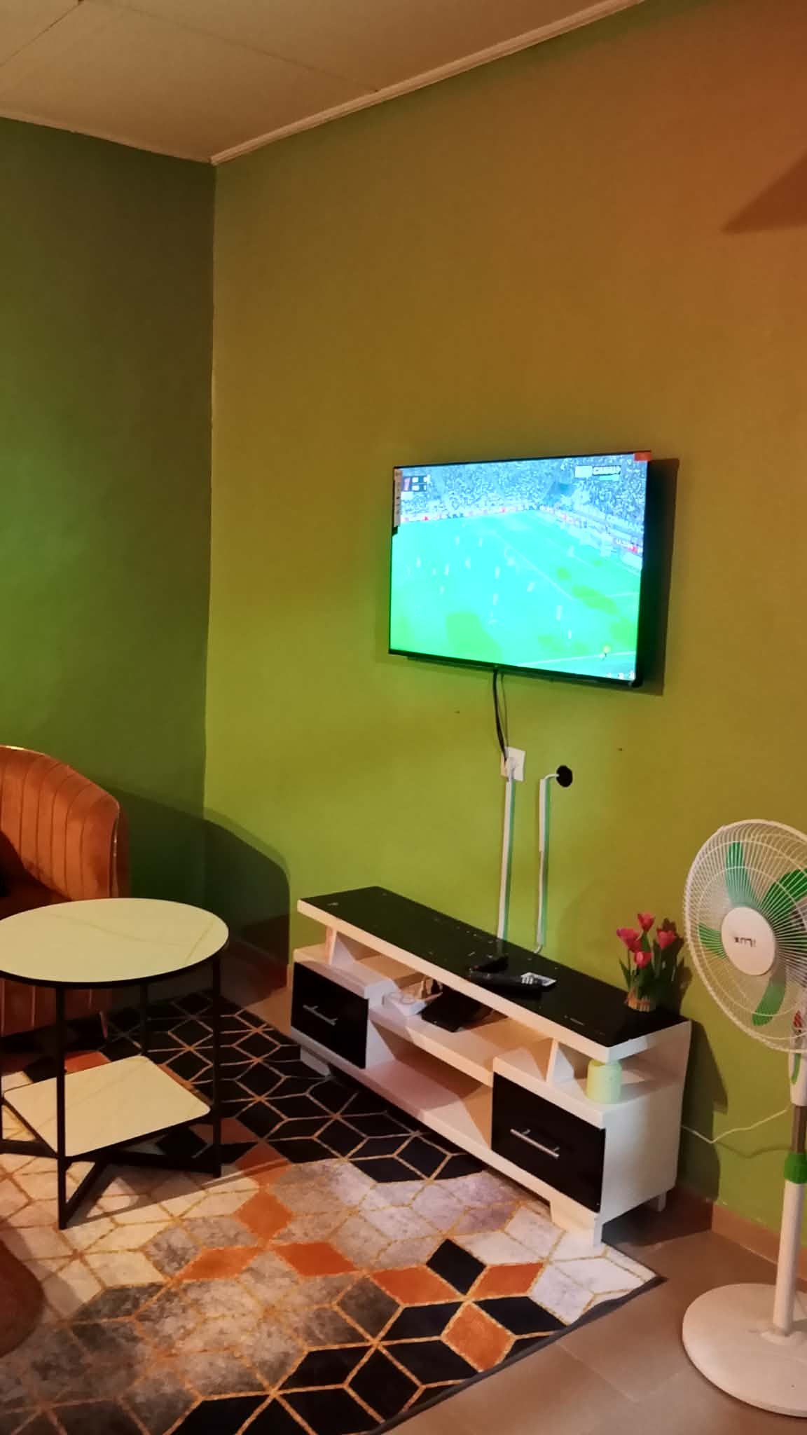 Coin salon avec téléviseur écran plat, meuble TV et ventilateur